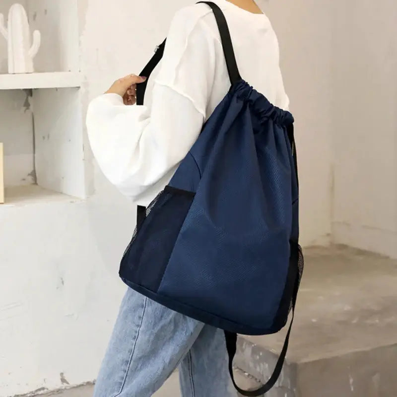 Navy blue drawstring backpack with side mesh pocket, large-capacity unisex bag