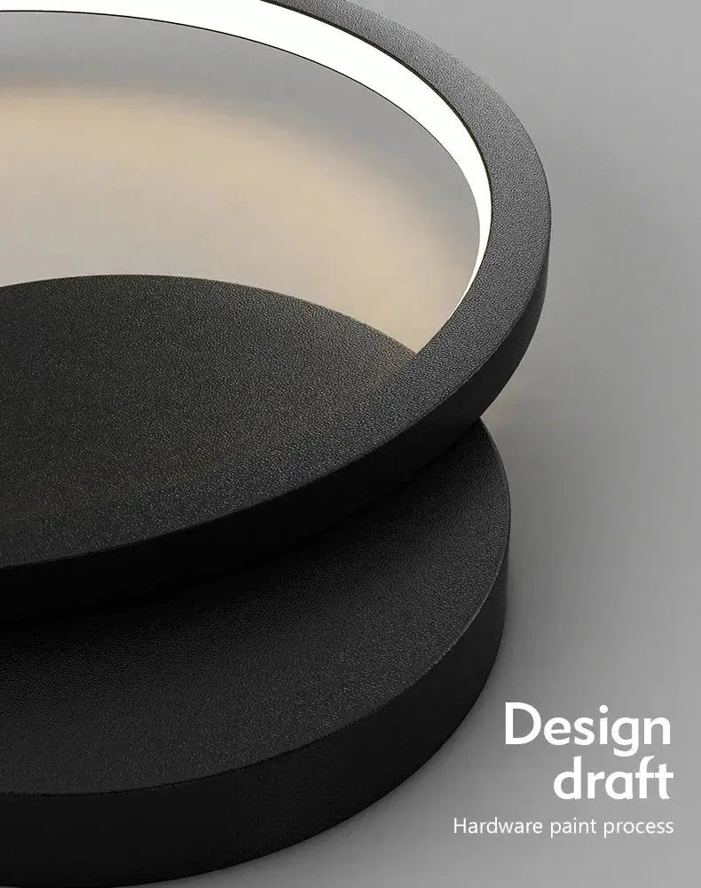 Modern LED wall lamp with circular black metal frame and white inner glow, ideal for living rooms or bedrooms.