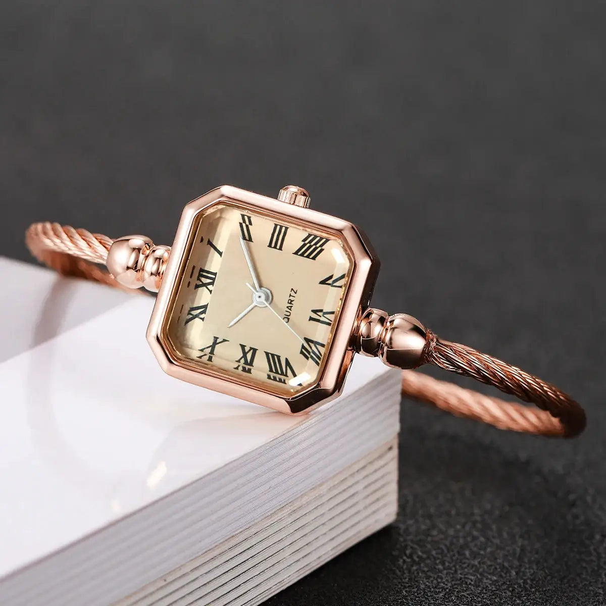 Women's rose gold square-dial quartz watch with Roman numerals and twisted rope bracelet
