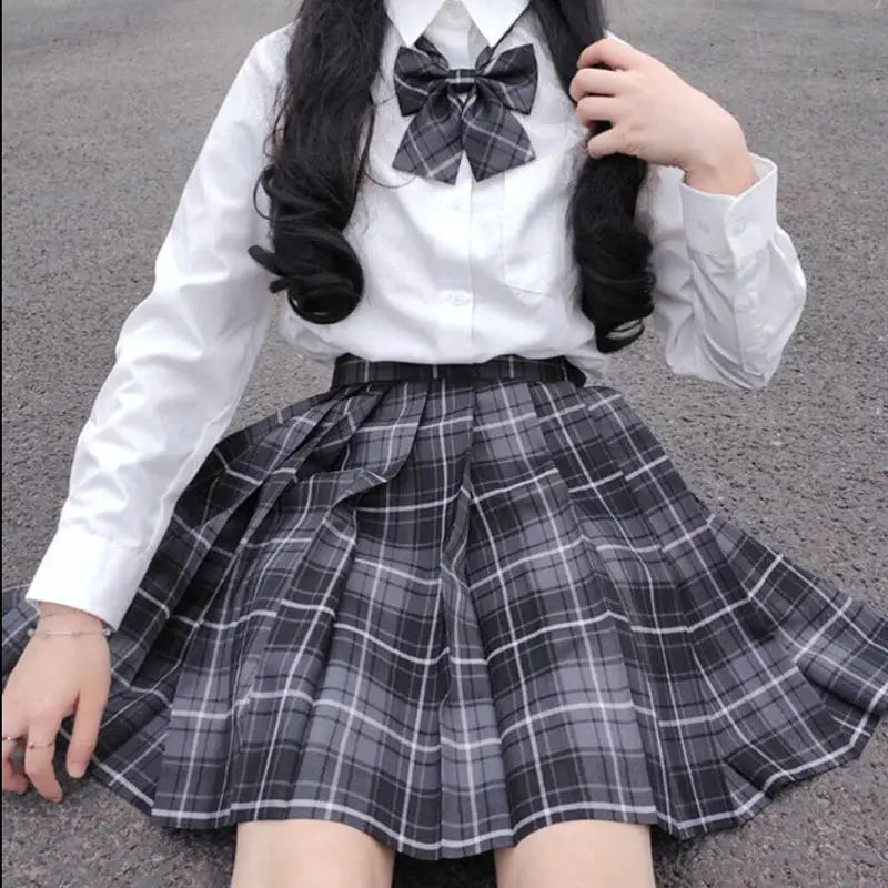 ZOKI plaid pleated skirt in gray plaid, worn with white blouse and bow for a school uniform look
