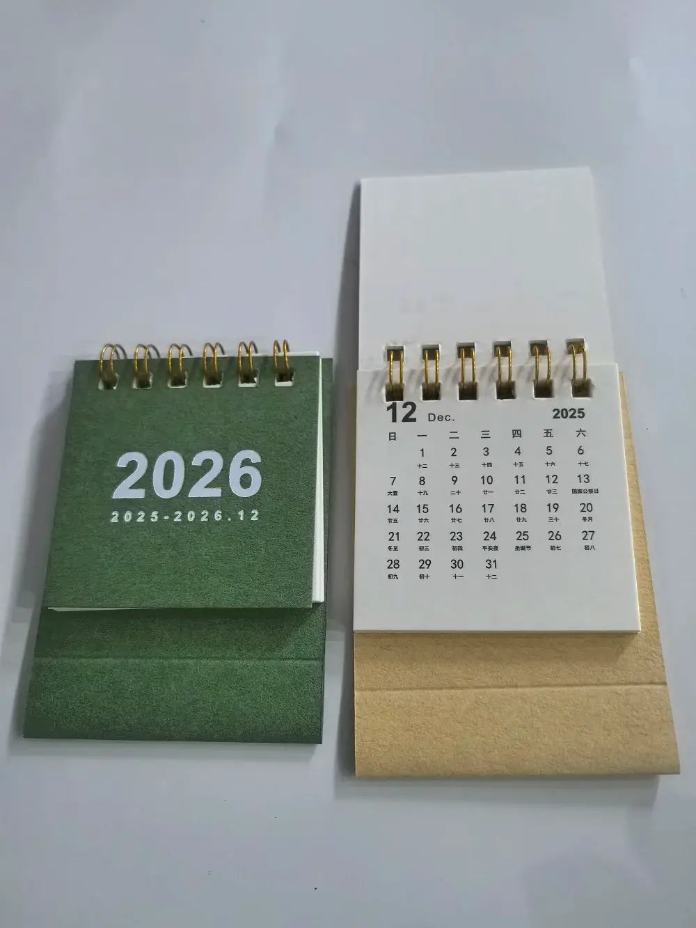 Two-piece mini desk calendar set: green calendar with gold coil rings and white page calendar with kraft sleeve