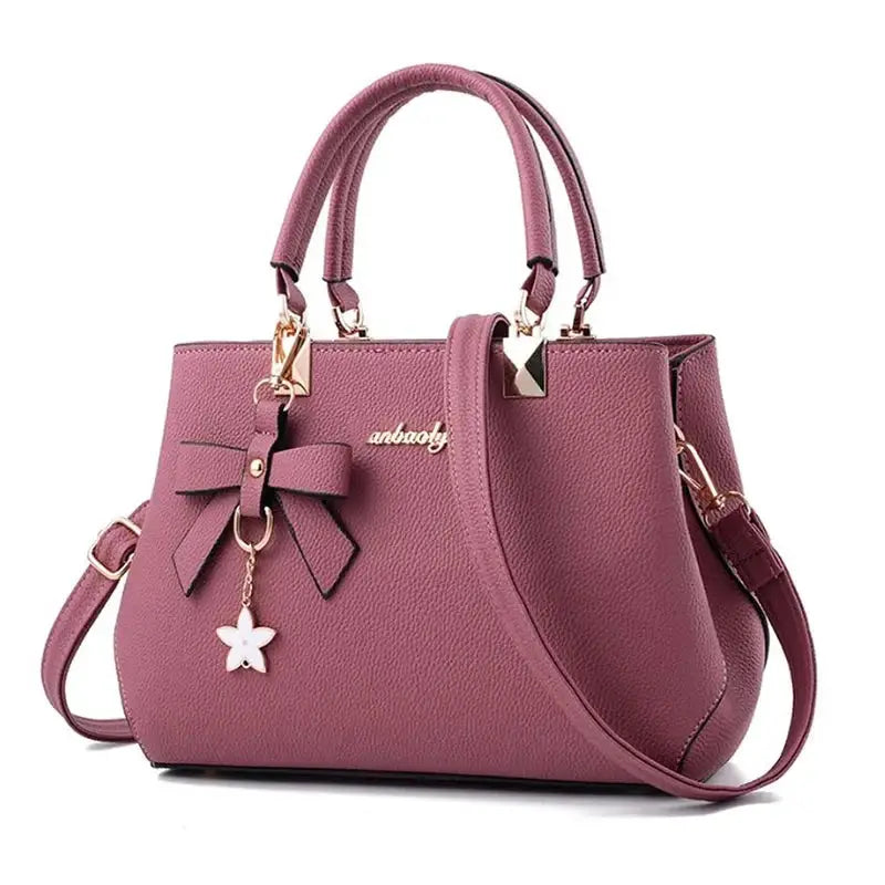 Pink pebbled handbag with bow charm and flower pendant, double top handles and detachable shoulder strap