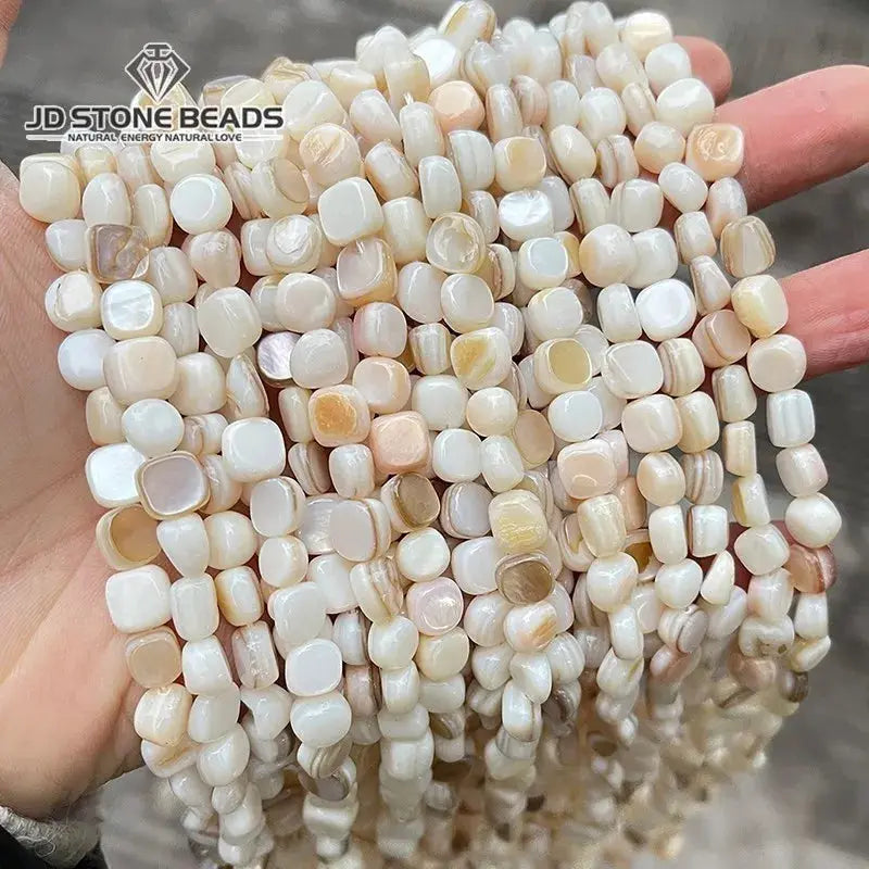 Natural shell beads, irregular square smooth spacers in cream and peach tones, multiple strands; JD Stone Beads logo.