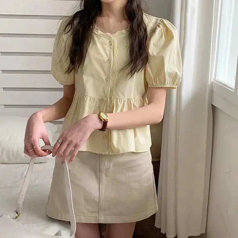 Women’s pale yellow puff-sleeve blouse with button-front and peplum waist
