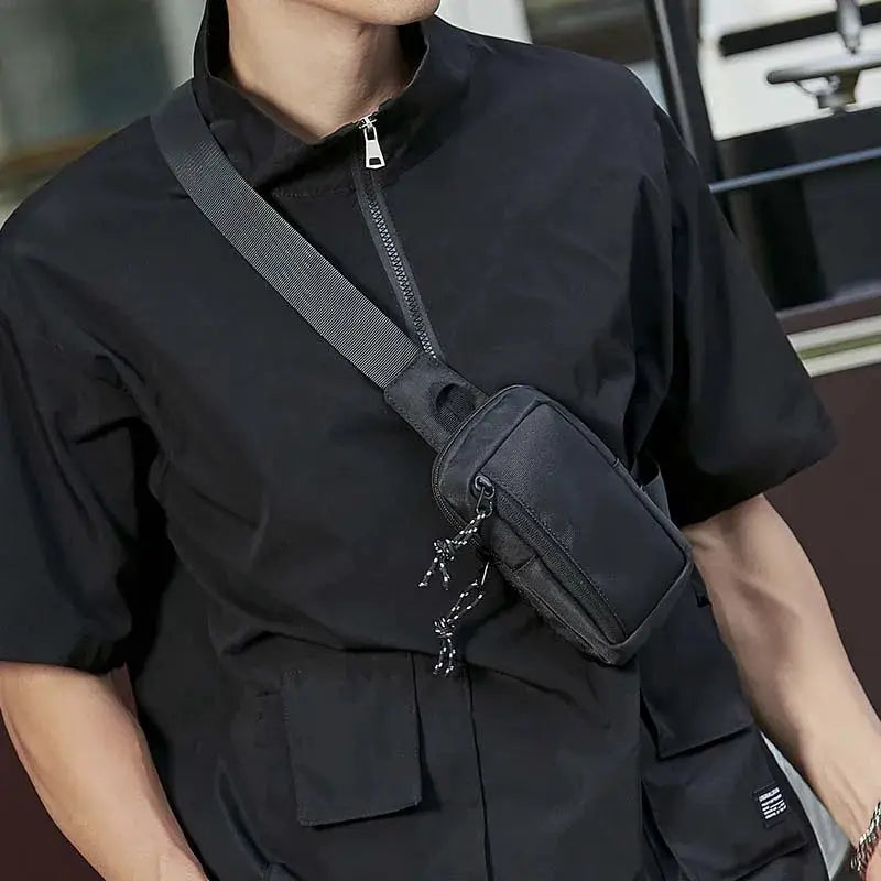 Crossbody mini chest bag in black with a gray adjustable strap, shown worn across the body by Simples Market.