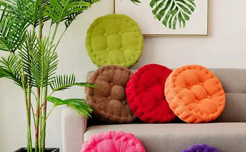 Tufted round seat cushions set of six (50x50cm) in green brown red orange pink and purple on a beige sofa.