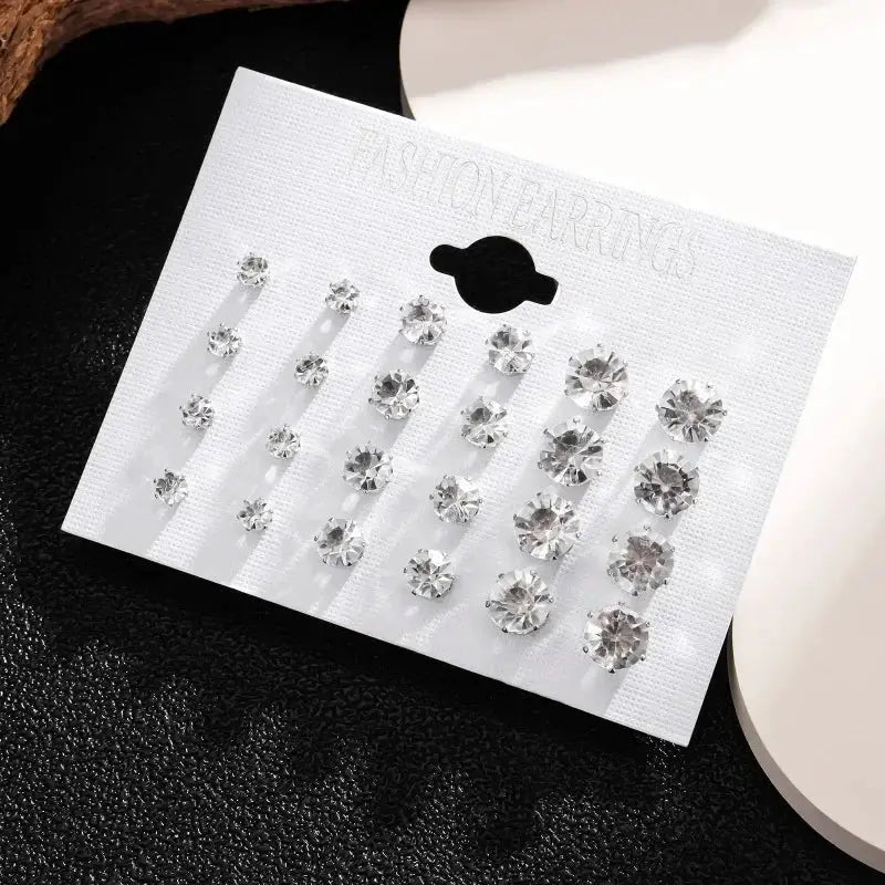 White crystal stud earrings set with 12 pairs displayed on a white card