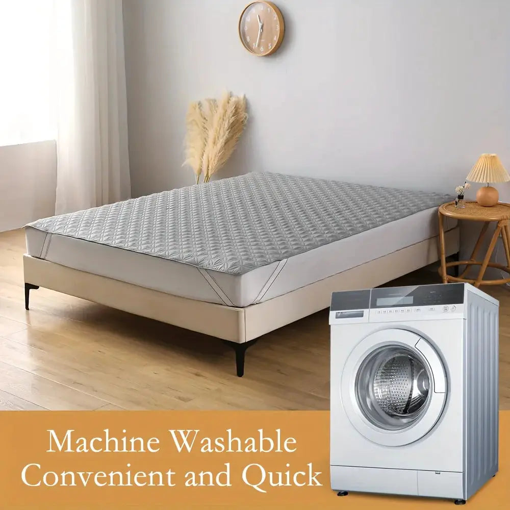 Waterproof mattress protector cover with elastic band on a grey quilted mattress; machine washable.