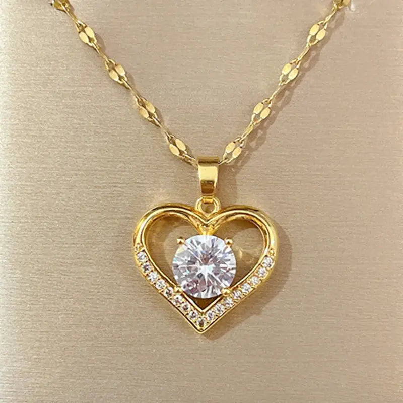 Gold-tone heart pendant necklace with a central clear gem and pavé crystals on the heart outline