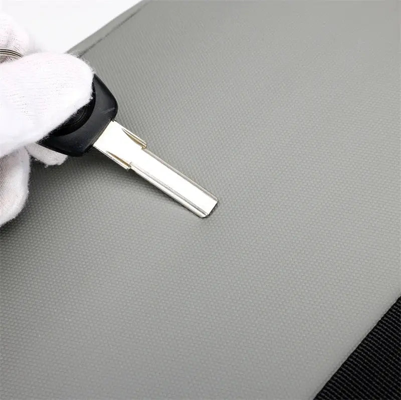 USB Charging Urban Man Backpack grey textured exterior close-up of a gloved hand holding a metal key