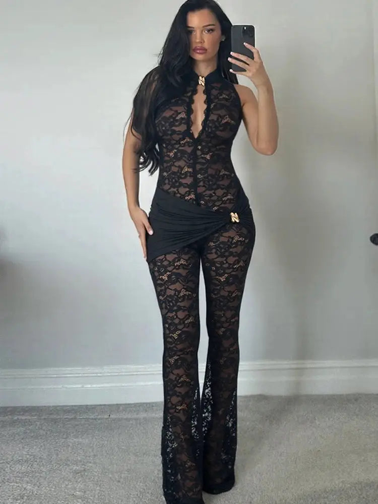 Black lace jumpsuit with sheer floral pattern, ruched waist and gold knot accent, wide-leg pants.
