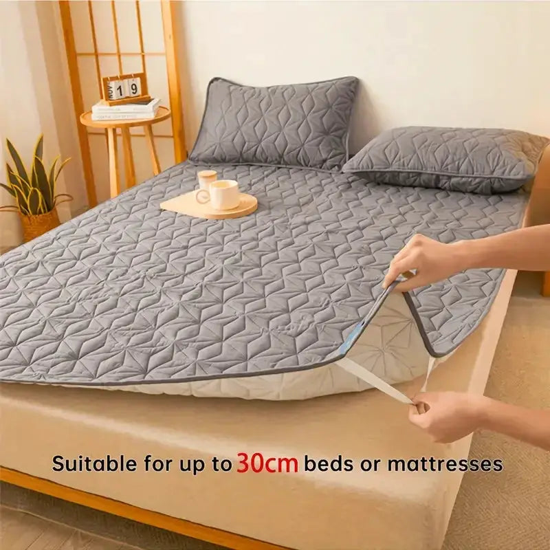 Waterproof Mattress Protector Simples Market; grey quilted cover with 4 elastic corner straps, fits up to 40 cm deep.