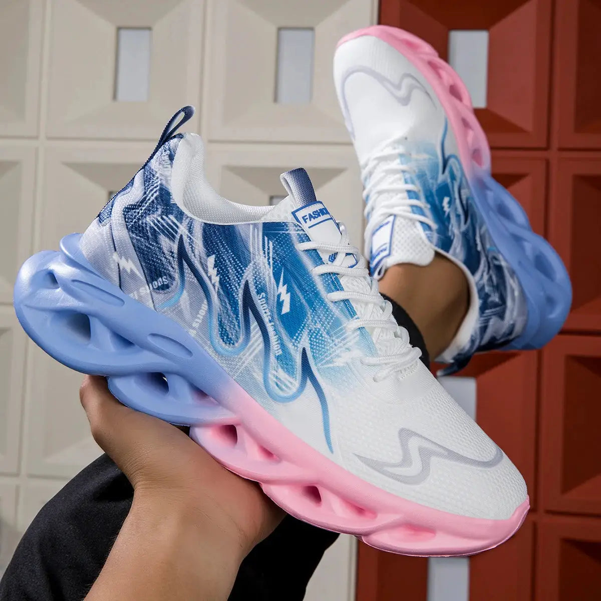 Unisex running shoes pair; white mesh upper with blue patterned sides and pink sole.