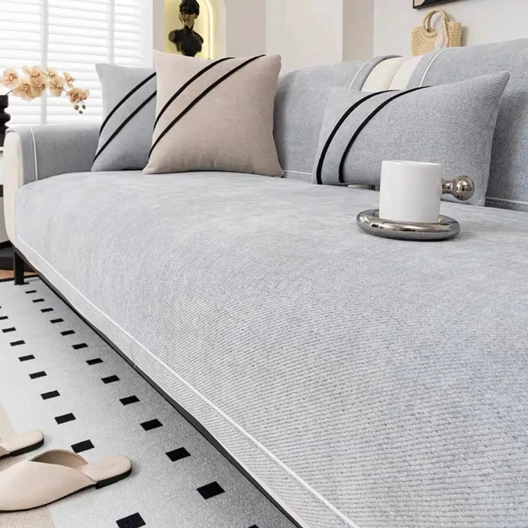 Heavy non-slip sofa protector in light gray chenille with decorative stitching by Simples Market.