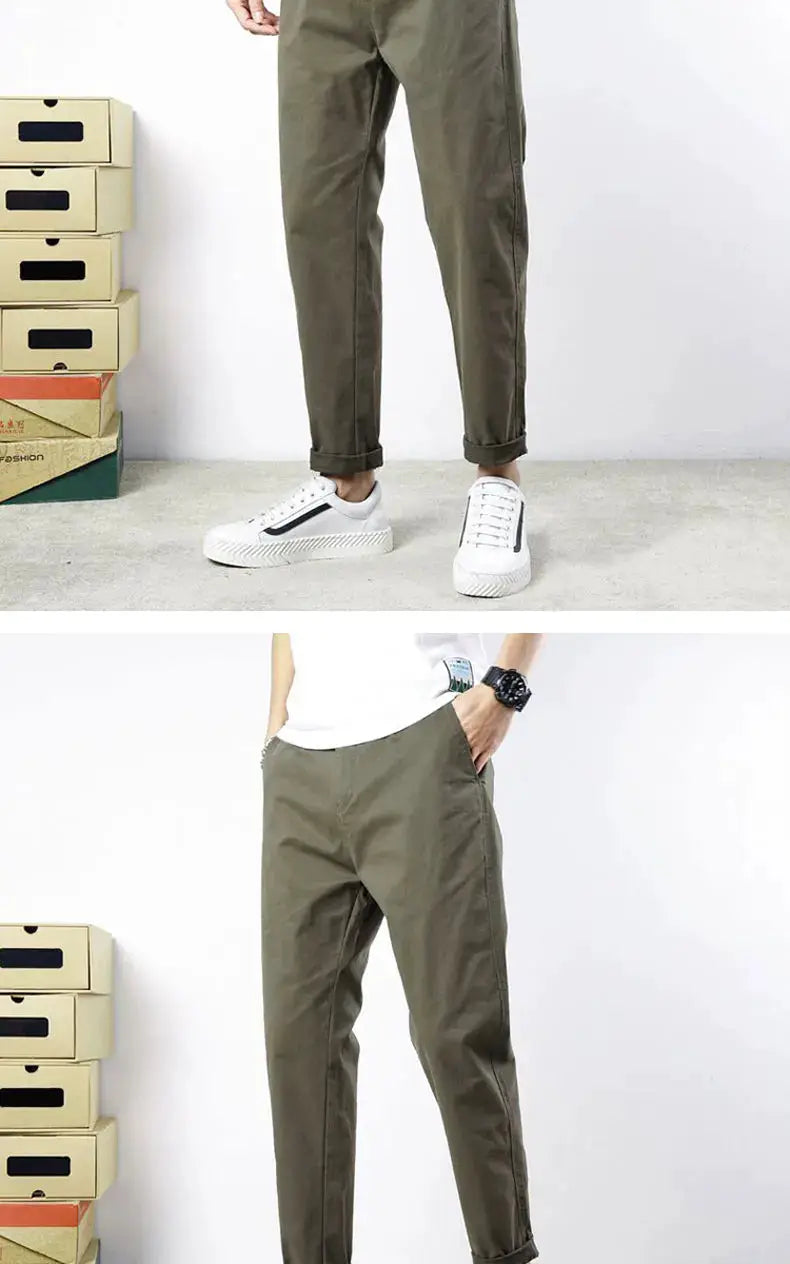 Men's olive green cotton casual pants with relaxed fit and rolled cuffs, shown with white sneakers.