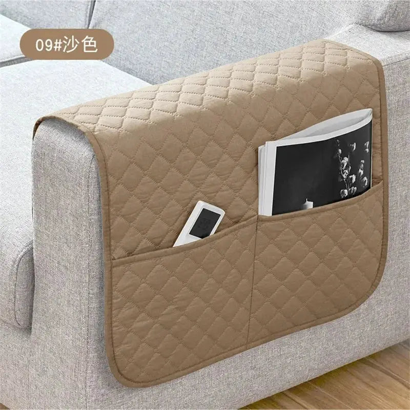 Sofa armrest cover with pockets in tan quilted fabric; water-repellent, holds remote and magazine.