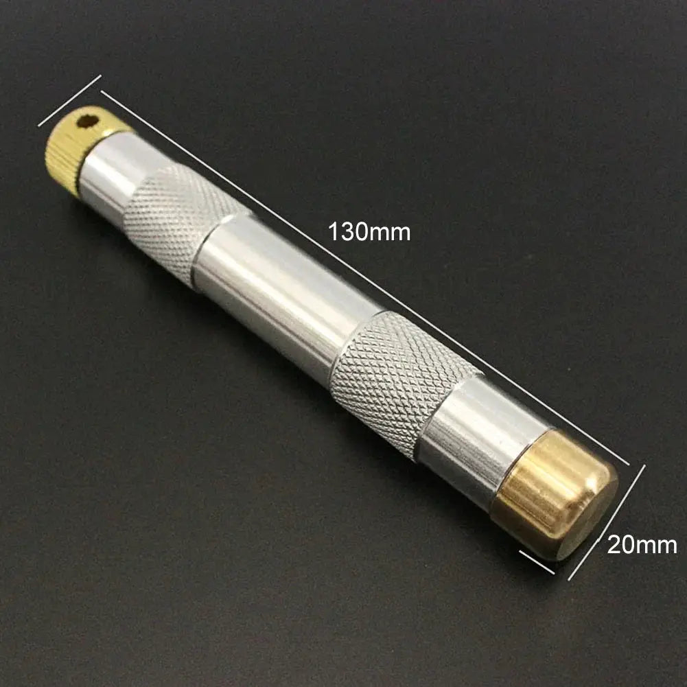 Brass emergency fire-start tube with knurled silver metal body and brass end caps, 130mm long and 20mm diameter