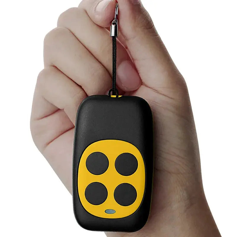 Remote control key fob with four yellow buttons on a black body, attached to a lanyard