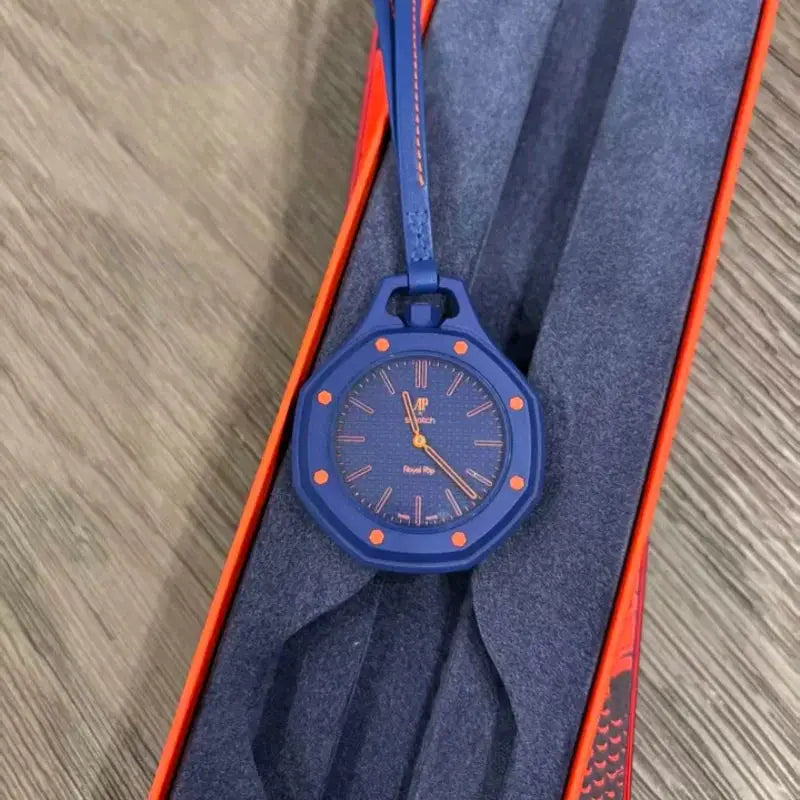 Wristwatch by AP Swatch in blue with orange markers and strap, Royal Oak style, in orange presentation box