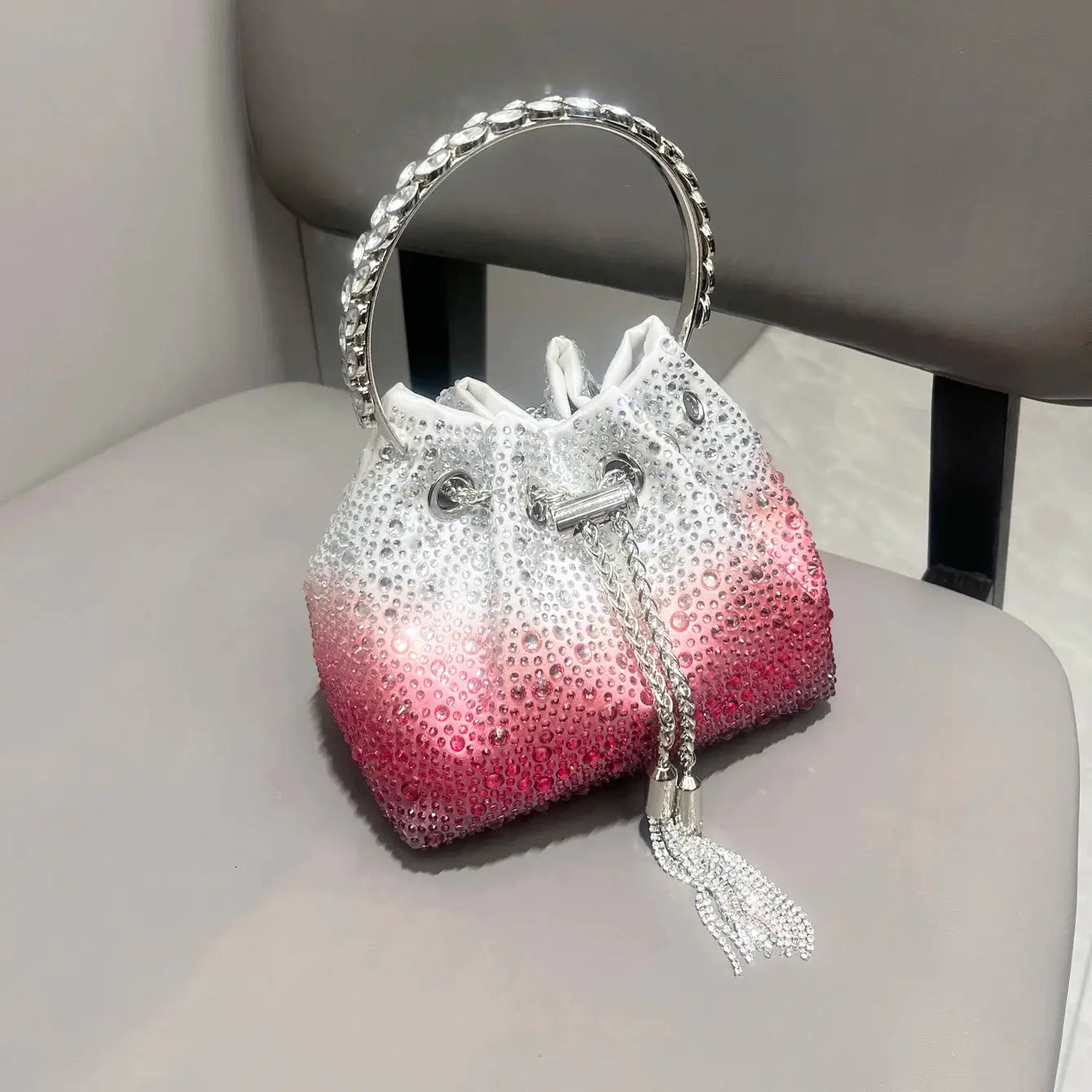 Rhinestone evening clutch with crystal circular handle, white-to-pink gradient, silver chain tassel