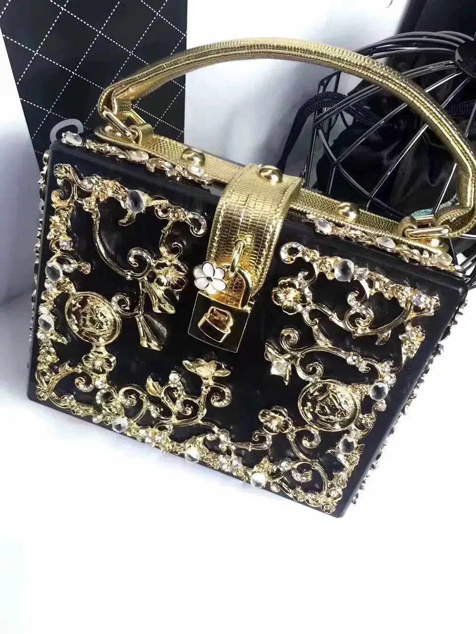 Evening bag in black with gold-tone hollow-out metal floral filigree and crystal accents