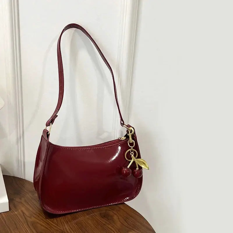 Women's cherry red PU leather shoulder bag with gold-tone hardware and cherry pendant charm