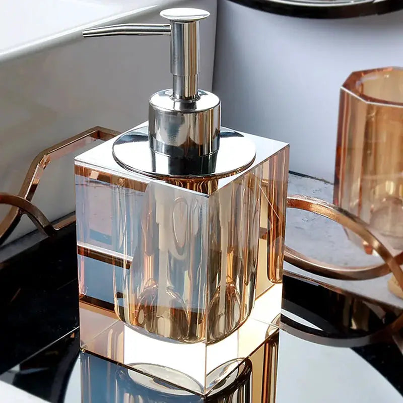 Glass lotion dispenser with silver pump on a clear crystal square bottle for bathroom use