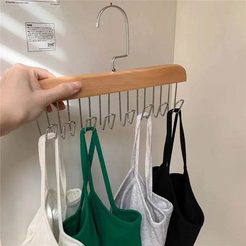 Simples Market bra hanger organizer with wooden bar and metal hooks; holds 4 bras in white, green, gray and black.