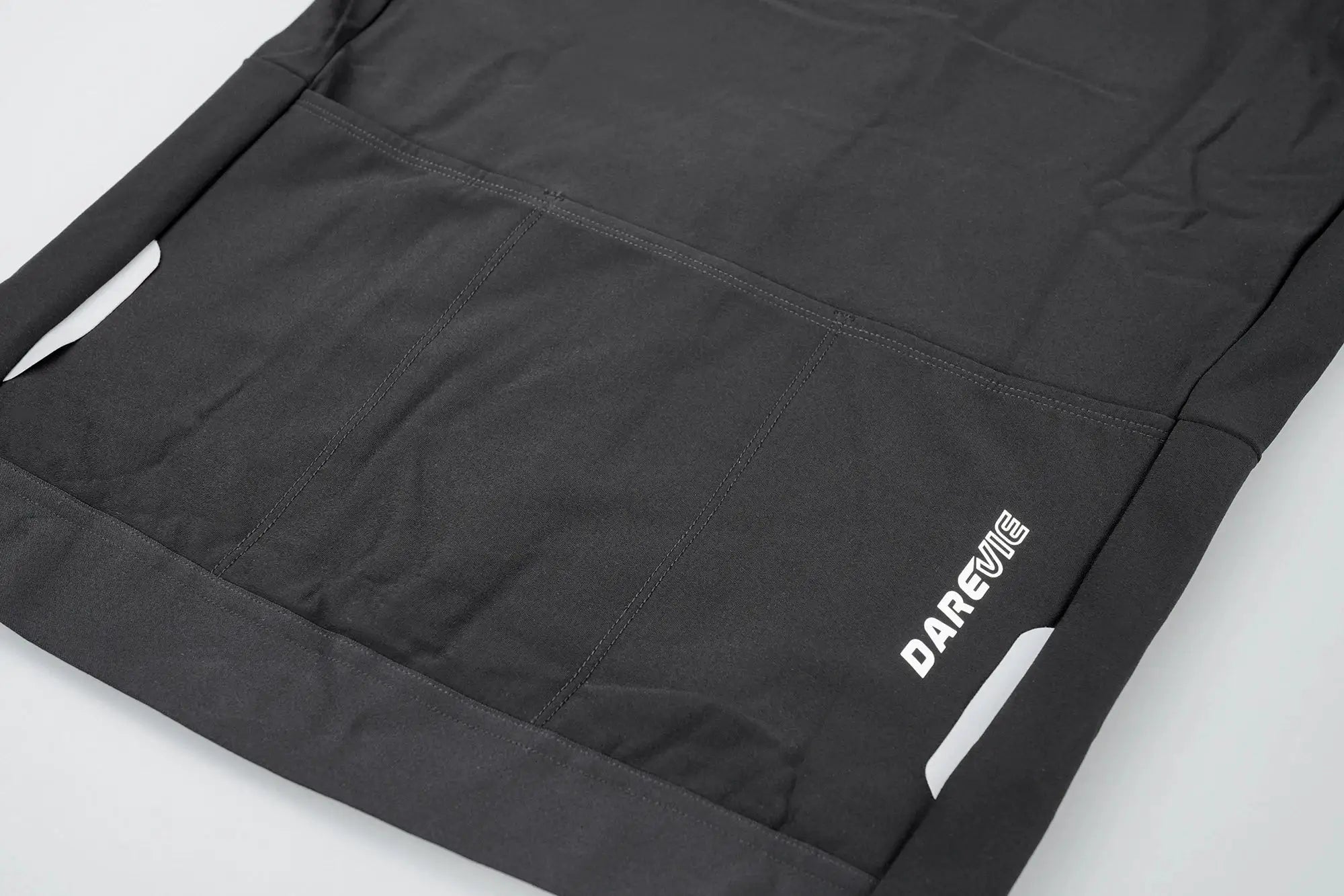 DAREVIE cycling jersey back view in black with rear pockets and white logo near hem