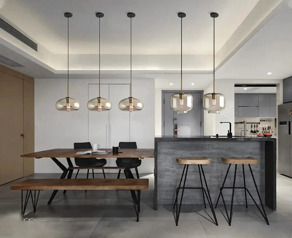 Nordic LED glass chandelier with five pendant heads and brass accents over a dining table.
