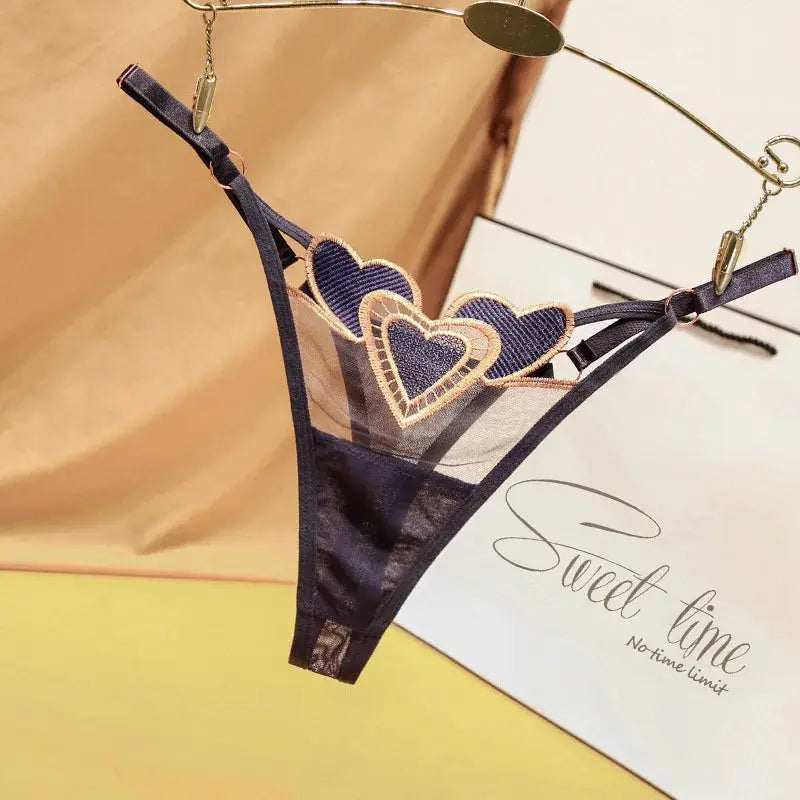 Simples Market women's navy blue thong with sheer mesh panels, adjustable side straps, and heart lace appliqués.