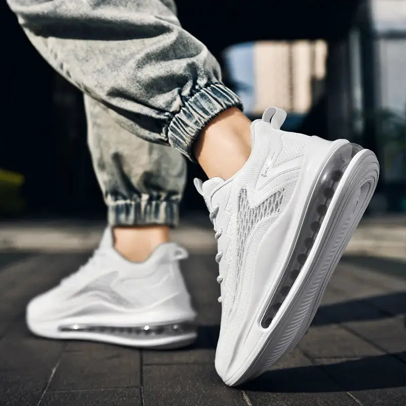 Pair of men's white breathable mesh running sneakers with air-cushion sole