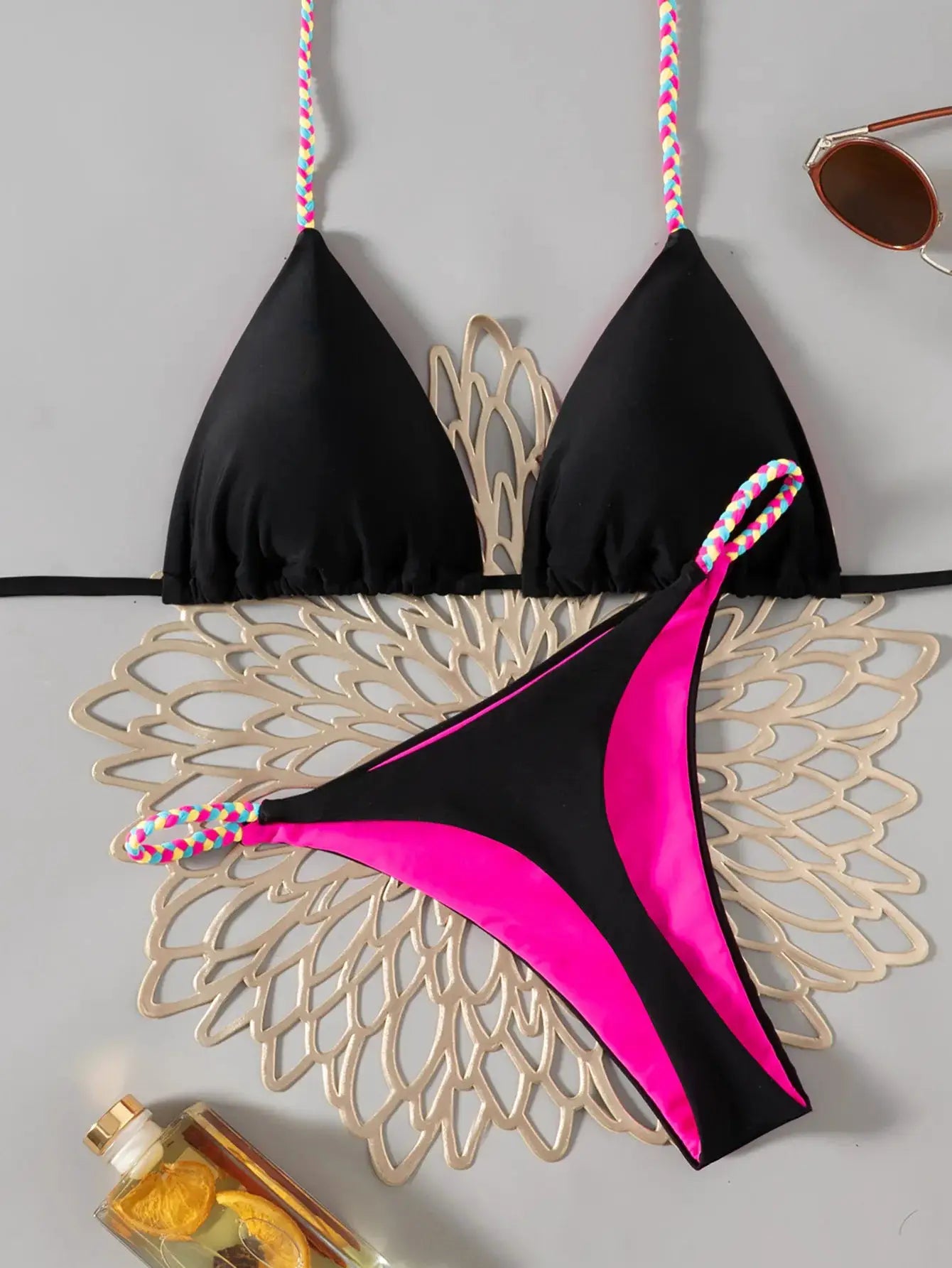 Women's bikini set with black triangle top, colorful braided straps, and pink/black tie-side bottom