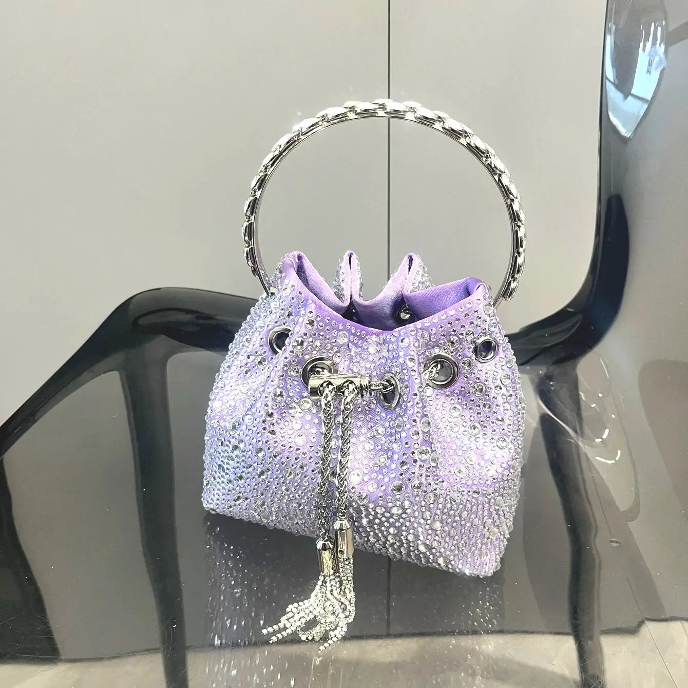 Rhinestone evening clutch bag in purple with a silver ring handle and crystal tassel