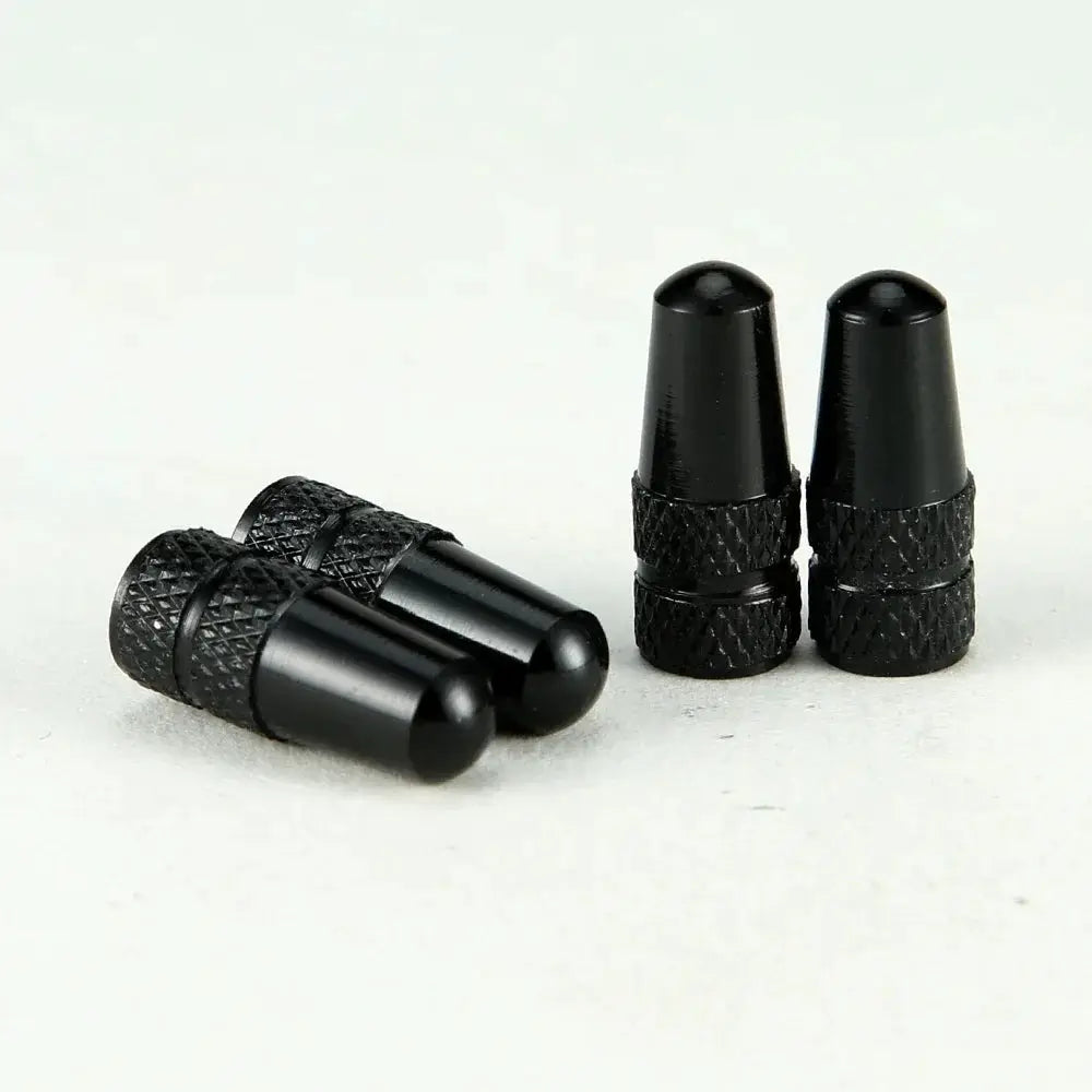 Set of 4 black aluminum alloy Presta valve caps for bicycle tires.
