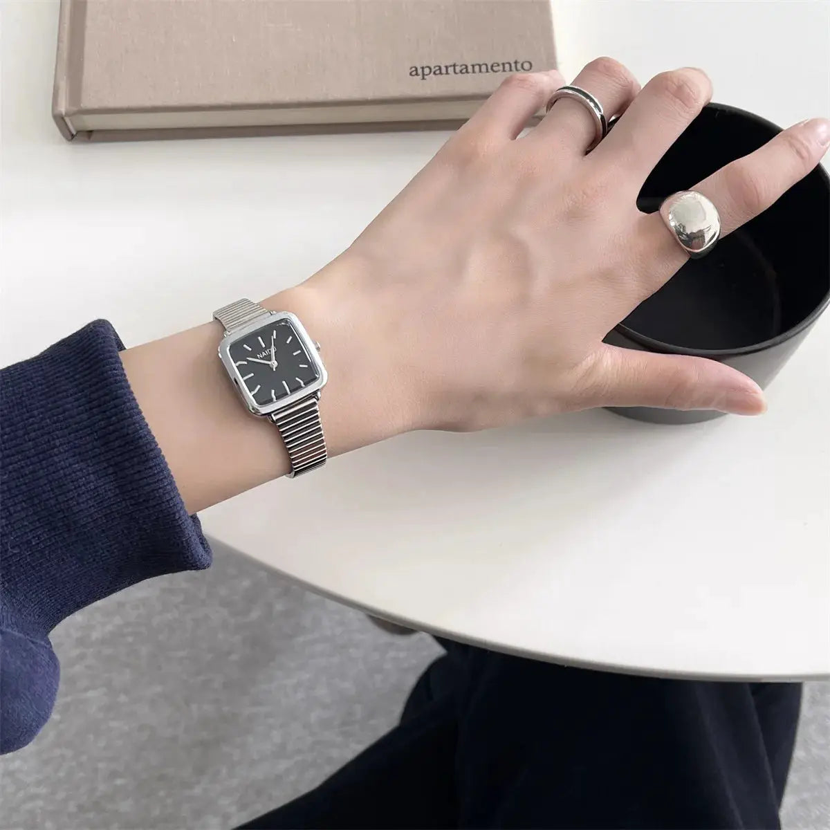 Simples Market women's square quartz watch with black dial and stainless steel mesh strap.