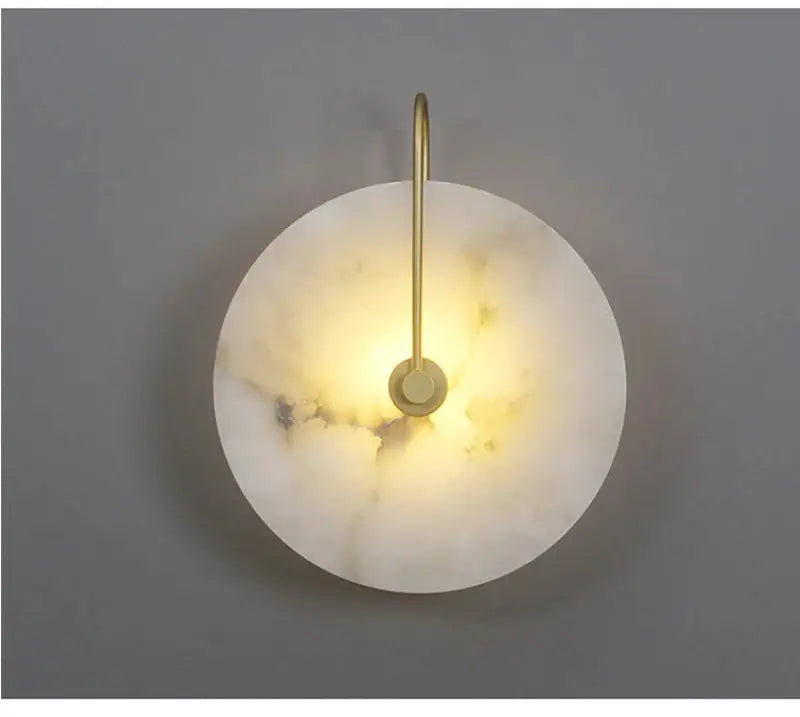 Nordic round marble moon wall sconce with brass arm and warm LED glow.