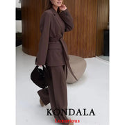 KONDALA brown women's blazer suit with a sash belt and matching wide-leg pants, carrying a black handbag