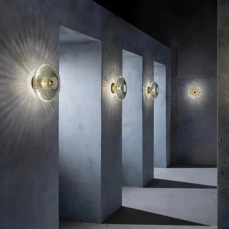 Nordic LED glass wall sconce set by Simples Market; five glass fixtures casting radial light on blue-gray corridor.