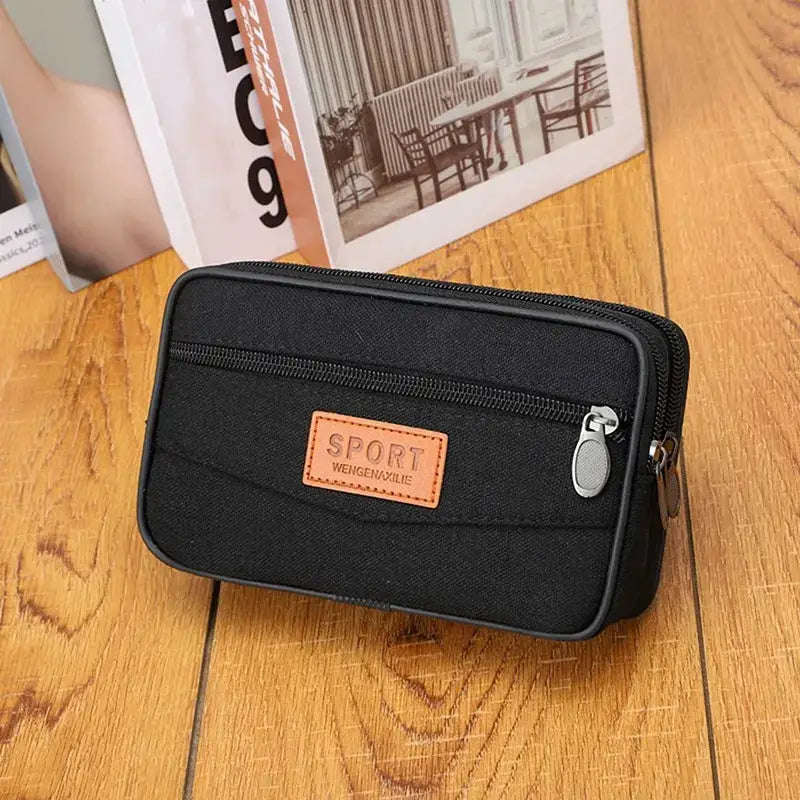 Men's black nylon waist pack with front zip pocket and orange logo patch