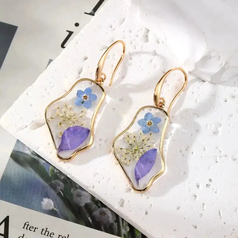 Flower earrings with gold-tone epoxy resin frames featuring blue and purple pressed petals (pair)
