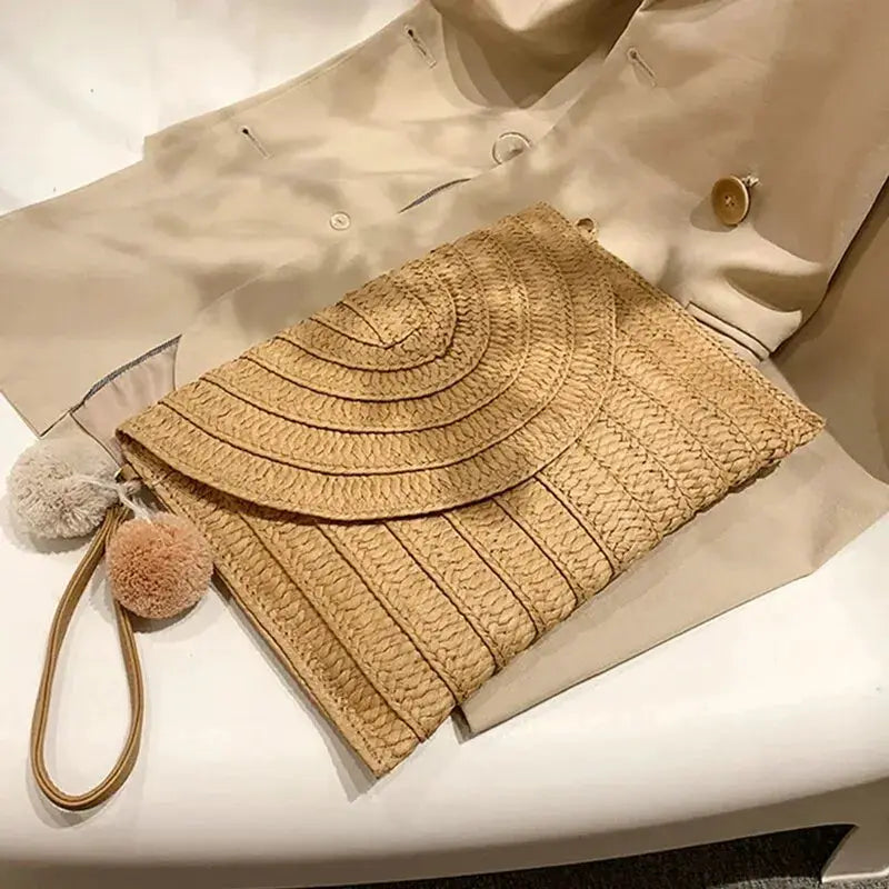 Handmade straw crossbody bag with envelope flap and pom-pom tassels