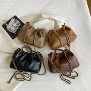 Four leather-look chain shoulder bags with gold-tone straps in black and brown tones