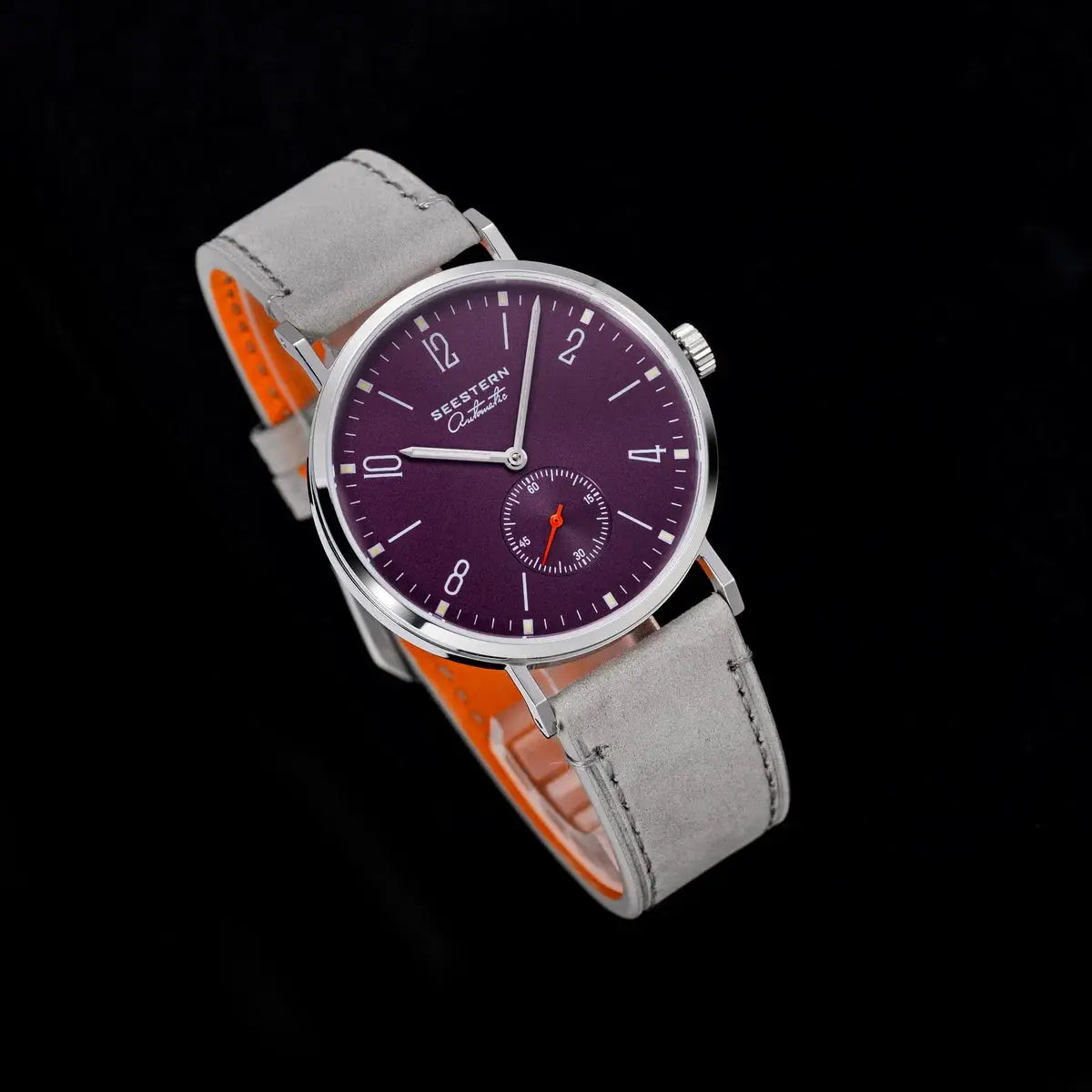 Seestern men's automatic wristwatch with purple dial and gray suede strap, shown against a black background.