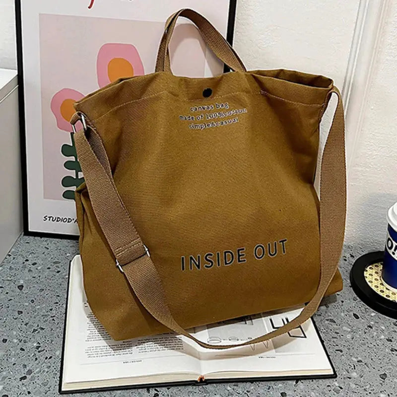 Brown canvas crossbody tote bag with top handles and adjustable strap, large capacity, INSIDE OUT branding