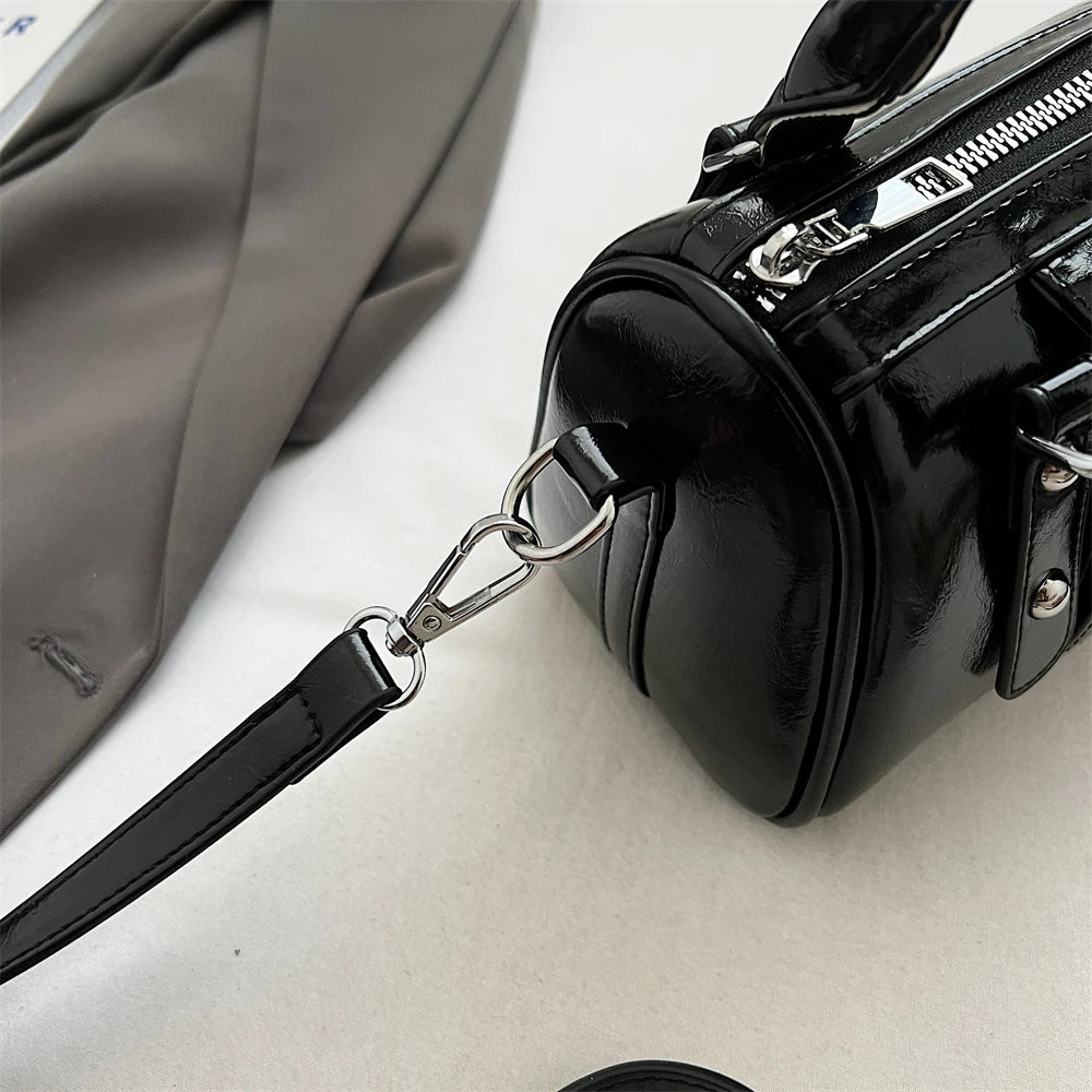 Mini top-handle bag in black patent PU leather with detachable shoulder strap and silver hardware.