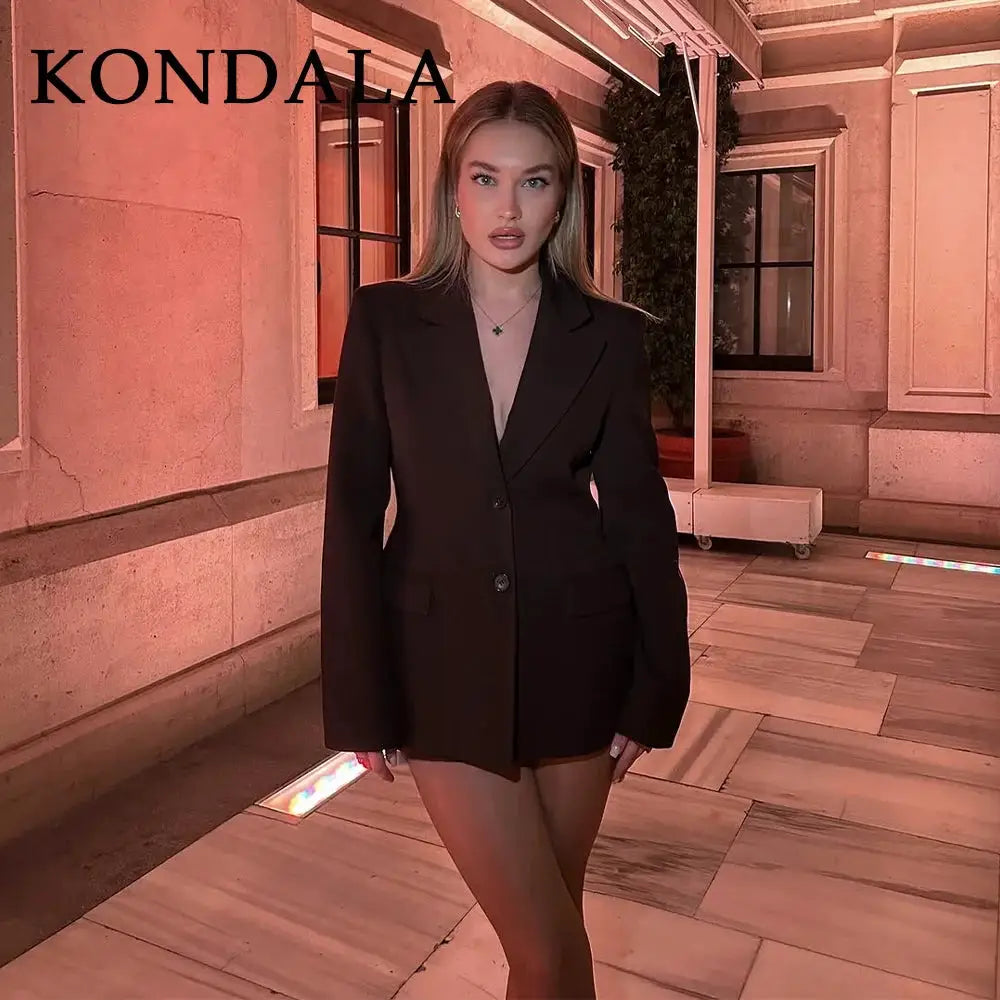 KONDALA black blazer with pockets worn by a model in pink-lit setting
