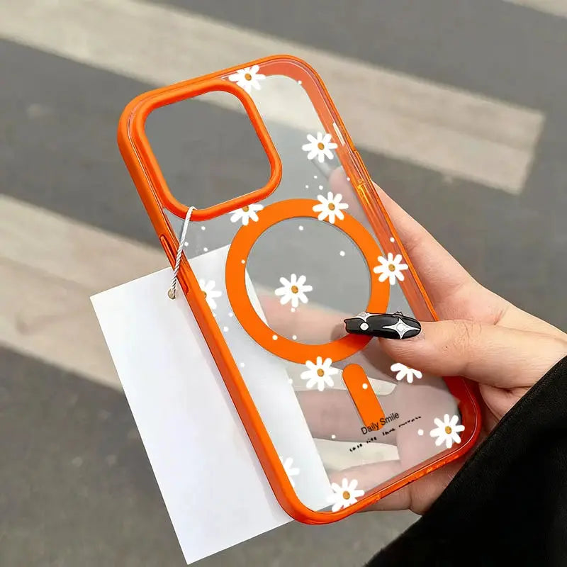 iPhone case with clear back, bright orange frame, white daisy pattern, and circular orange magnetic ring grip