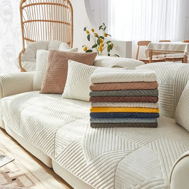 Crystal Velvet sofa cover set on a cream sectional, non-slip quilted protector with color options stacked.
