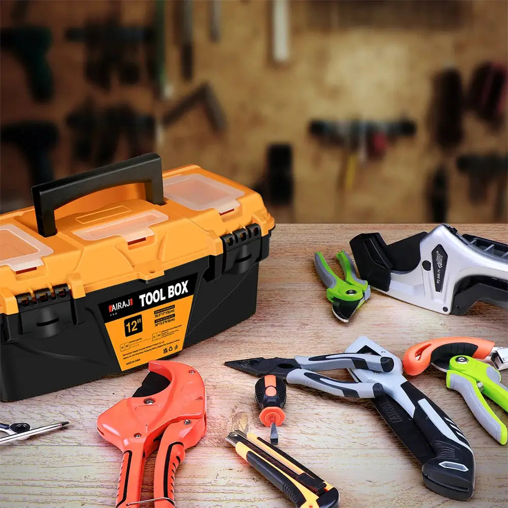 Airaj 12-inch plastic tool box with orange lid and black base, shown with pliers and cutters on a workbench